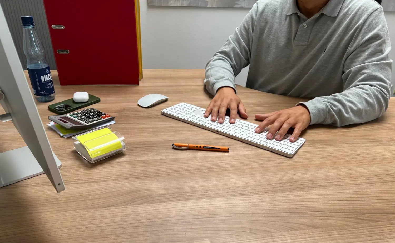 Ein Mann benutzt die Tastatur auf dem Tisch von Lohn- und Büroservice Plus